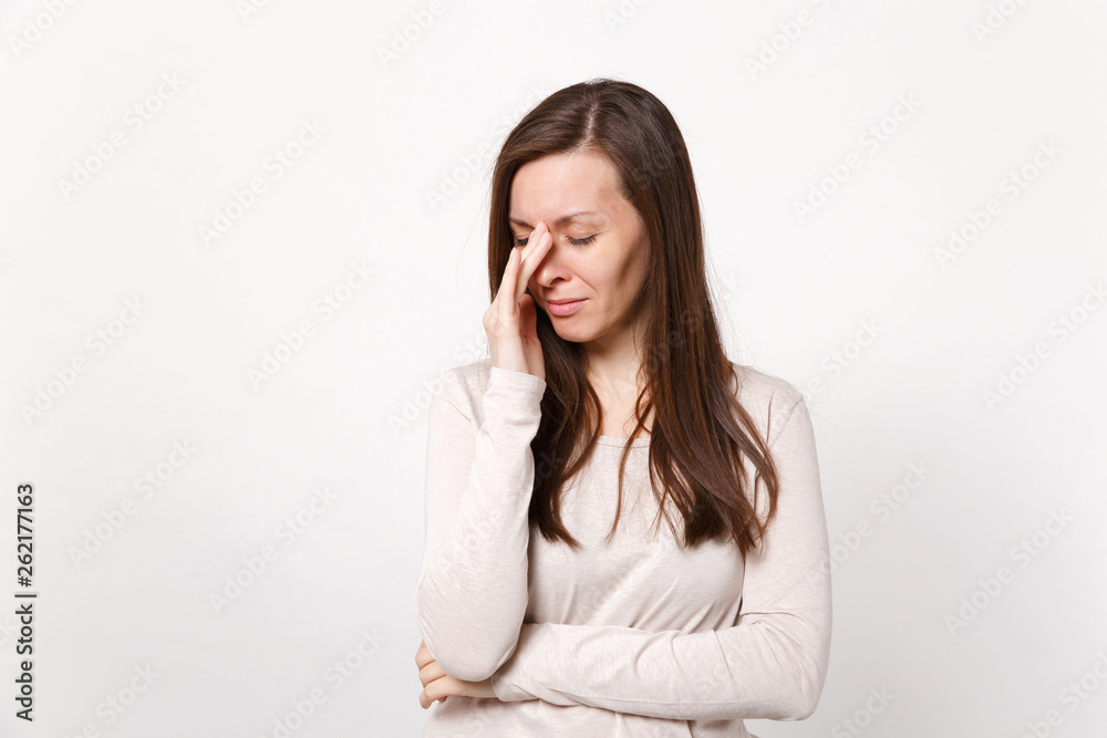 Portrait of tired crying dissatisfied young woman in light clothes wiping tears with hand isolated on white wall background in studio. People sincere emotions, lifestyle concept. Mock up copy space. Portrait of tired crying dissatisfied young woman in light clothes wiping tears with hand isolated on white wall background in studio. People sincere emotions, lifestyle concept. Mock up copy space.