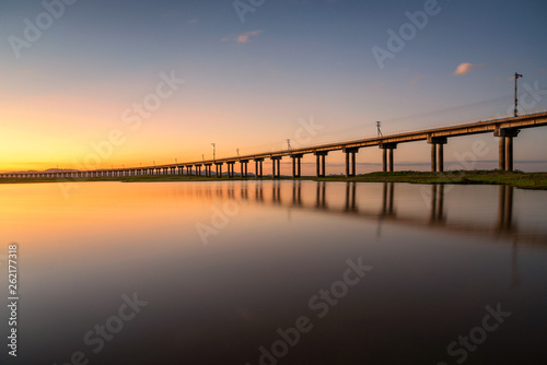 Beautiful sunset scene of railway bridge in lake of pasak Dam , Lopburi , Thailand