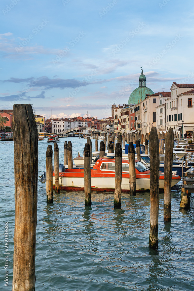 old wooden poles and boats parked on the Grand Canal in Venice