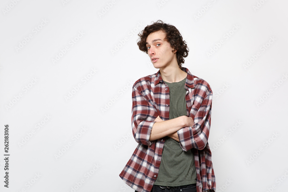 Portrait of amazed young man in casual clothes looking camera and holding hands crossed isolated on white wall background in studio. People sincere emotions, lifestyle concept. Mock up copy space. Portrait of amazed young man in casual clothes looking camera and holding hands crossed isolated on white wall background in studio. People sincere emotions, lifestyle concept. Mock up copy space.