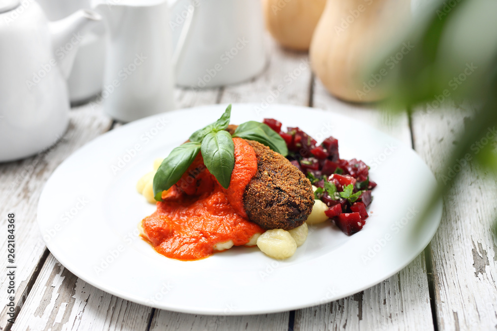 Vegetable cutlets served with tomato sauce on dumplings on gnocchi, roasted beetroot salad.