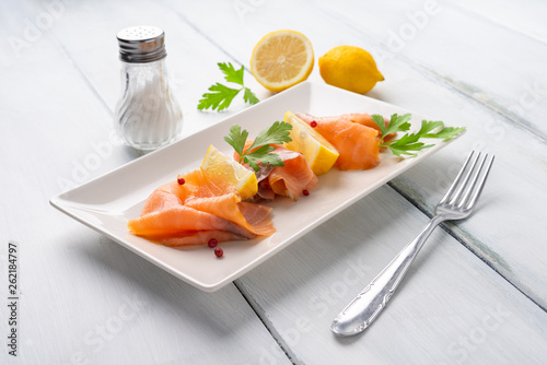 Piatto con fette di salmone affumicato e limone fresco photo