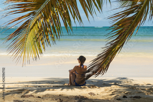 Traveler girl relaxing on tropical beach.