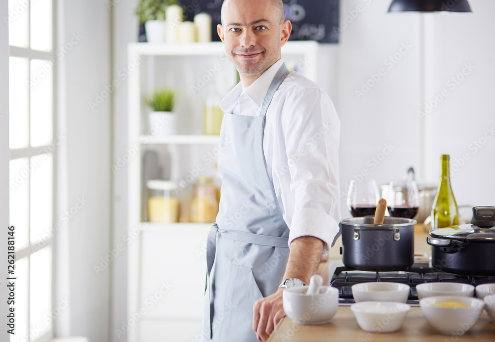 Handsome man is cooking on kitchen and smiling Handsome man is cooking on kitchen and smiling