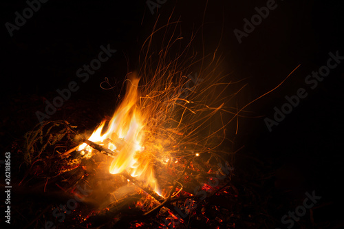 Bonfire in the night. Beautiful orange sparkles on a black background.