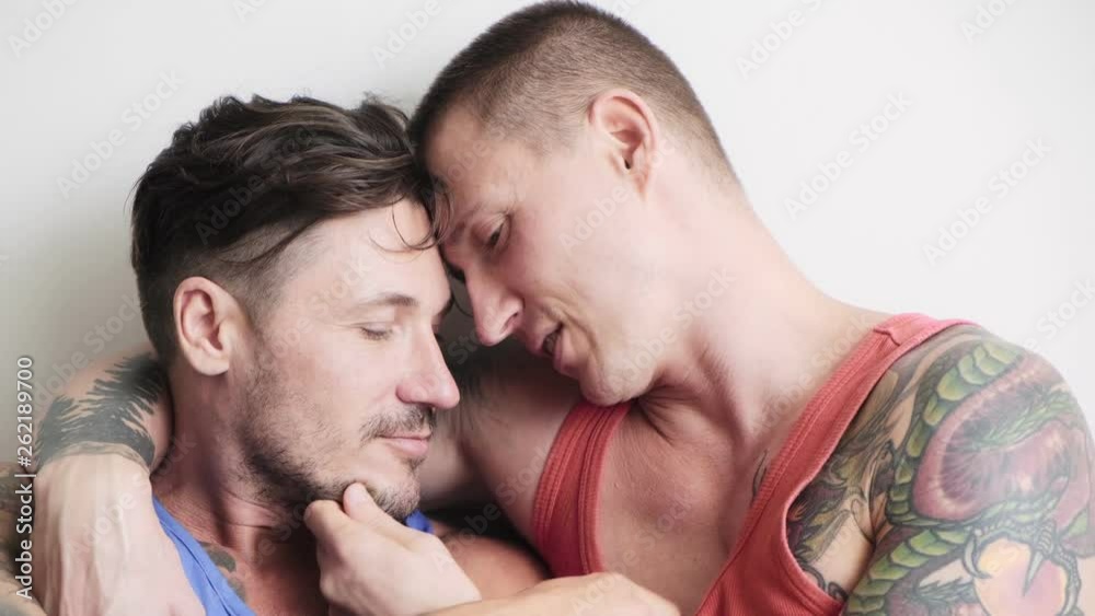 Young gay male couple in bed together, intimate. Touching each other. Happy gay friendship, relationship, pride concept. Young gay male couple in bed together, intimate. Touching each other. Happy gay friendship, relationship, pride concept.