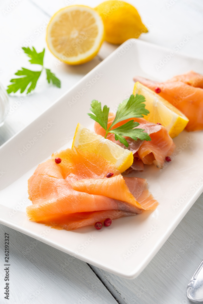 Piatto con fette di salmone affumicato e limone fresco Piatto con fette di salmone affumicato e limone fresco
