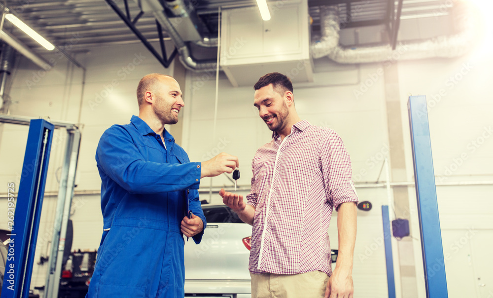 auto service, repair, maintenance and people concept - mechanic with clipboard giving key to happy smiling man or owner at car shop auto service, repair, maintenance and people concept - mechanic with clipboard giving key to happy smiling man or owner at car shop
