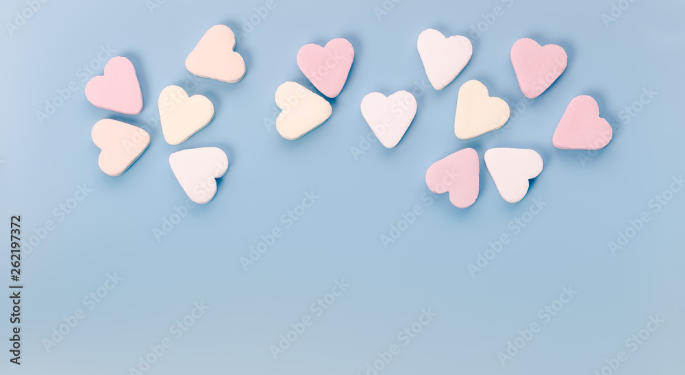 Candy hearts on blue background.