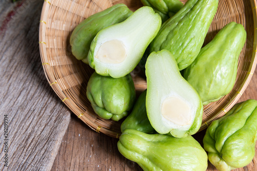 Fresh chayote fruits (Sechium edulis) on wood background photo