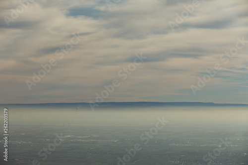 Landschaft Rheinebene mit Windrädern unter einer Nebeldecke und Wolkendecke