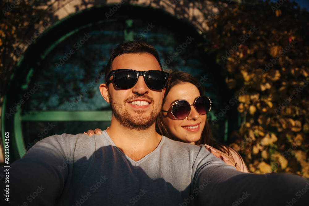 Selfie of beautiful couple in sunglasses outside. Autumn weather Selfie of beautiful couple in sunglasses outside. Autumn weather