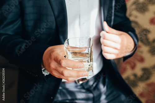 groom holds a glass of whiskey