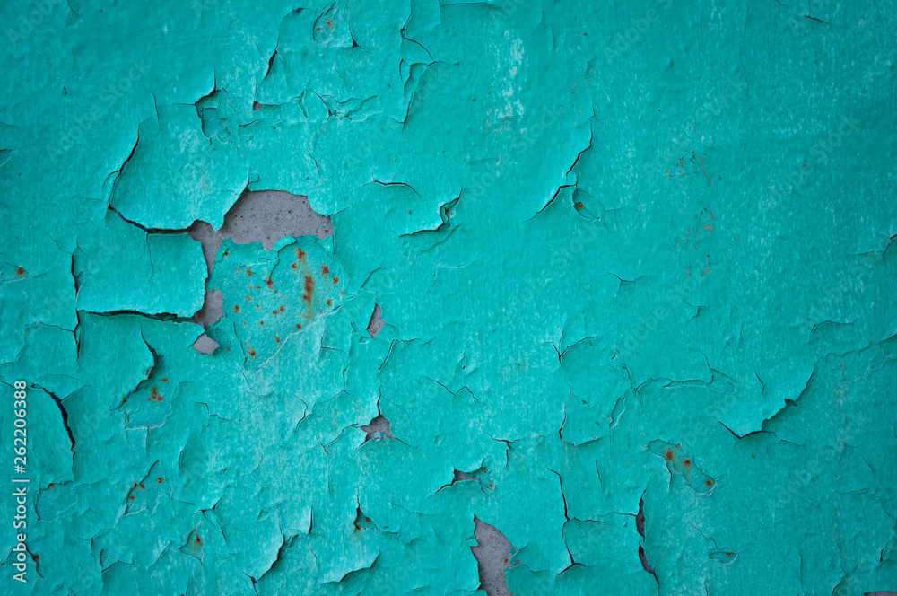 Old turquoise wall with cracks and the exfoliated paint