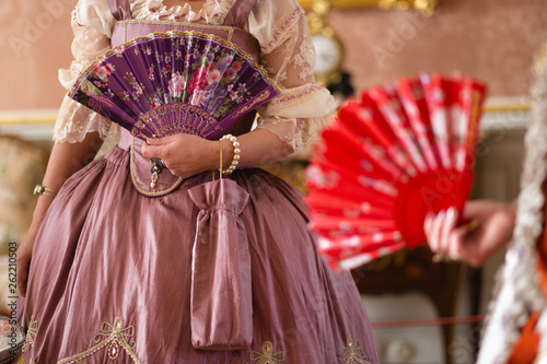 Retro style royal medieval ball - Majestic palace with gorgeous people dressed in king and queen's friends dresses with accessories such as fan and hand puch as a handbag - 2019