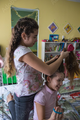 Wallpaper Mural Young Girl Braiding Her Friends Hair. Smiling girl during braiding hair.Selected focus Torontodigital.ca