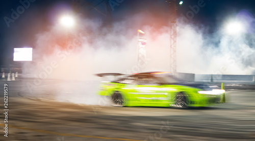 Blurred of speed car drifting on racing track at night.
