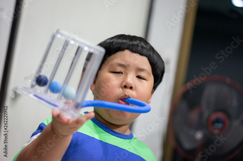 A boy is testing and administering lungs with a tri-ball dryer.