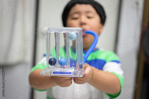 A boy is testing and administering lungs with a tri-ball dryer.