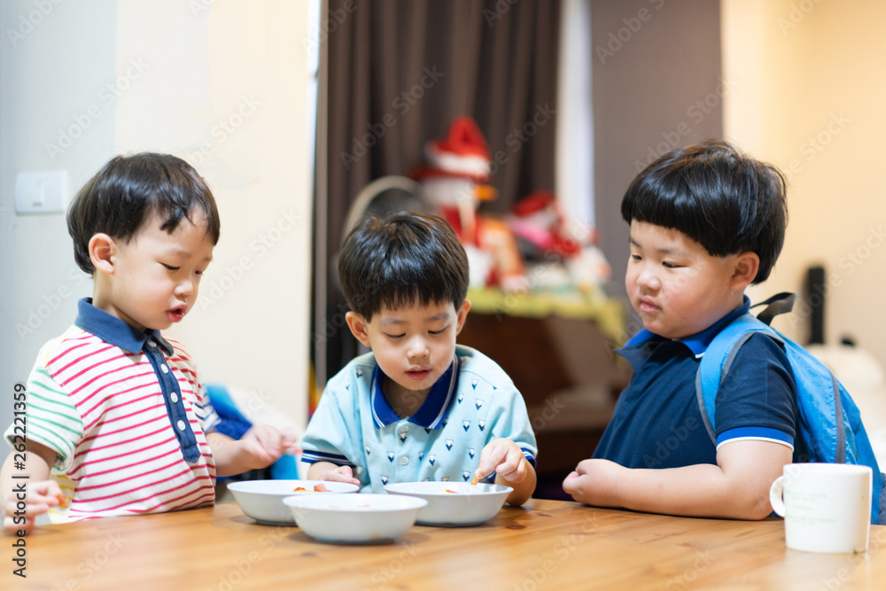The brothers are enjoying their favorite omelet before going to school. The brothers are enjoying their favorite omelet before going to school.