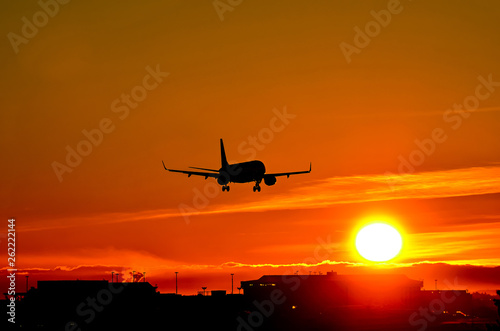 Airplane landing to sunset