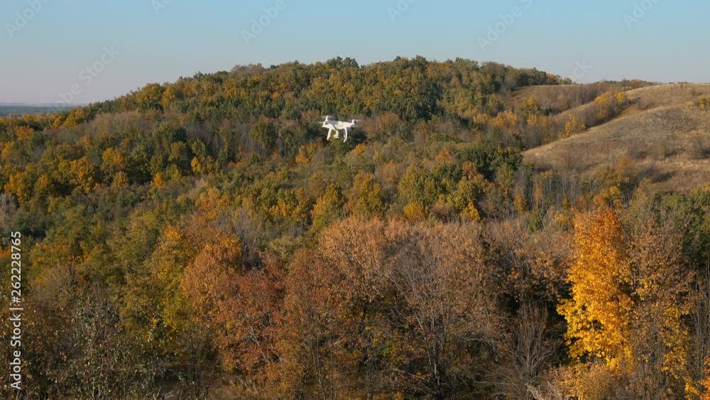 Drone in flight over deciduous forest in hilly countryside. Drone in flight over deciduous forest in hilly countryside.