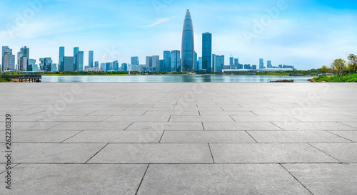 Empty square tiles and skyline of urban buildings