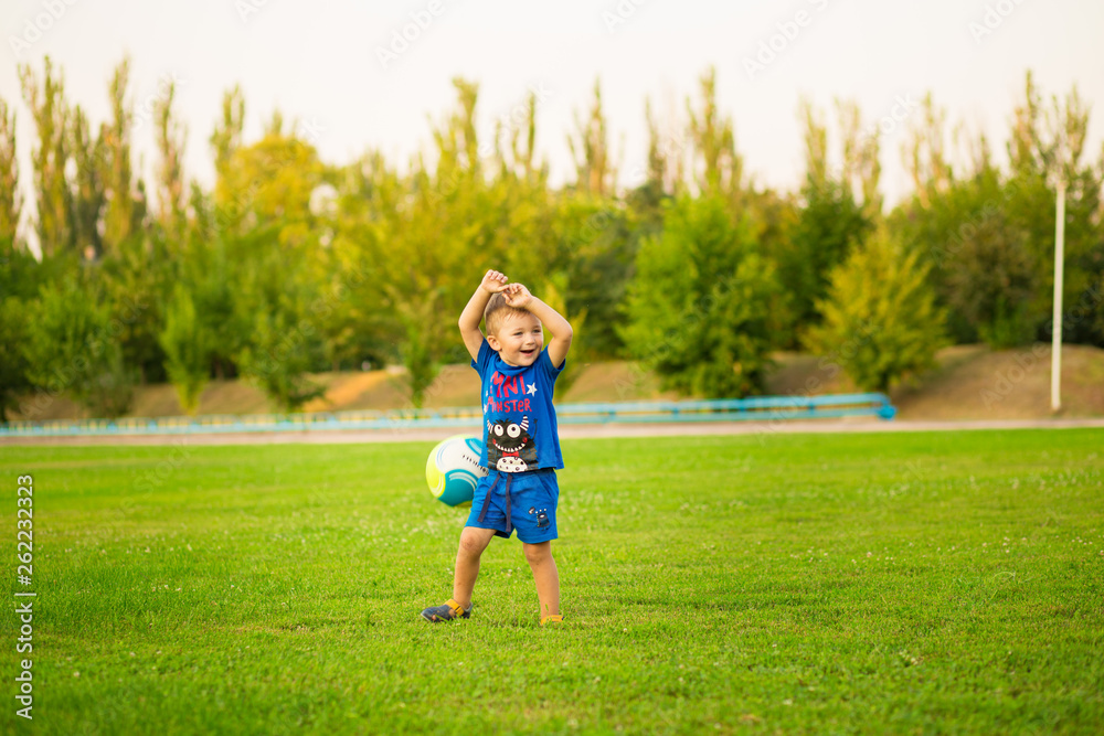 DNEPR, UKRAINE - AUGUST 13, 2018: little funny boy play on football stadium DNEPR, UKRAINE - AUGUST 13, 2018: little funny boy play on football stadium