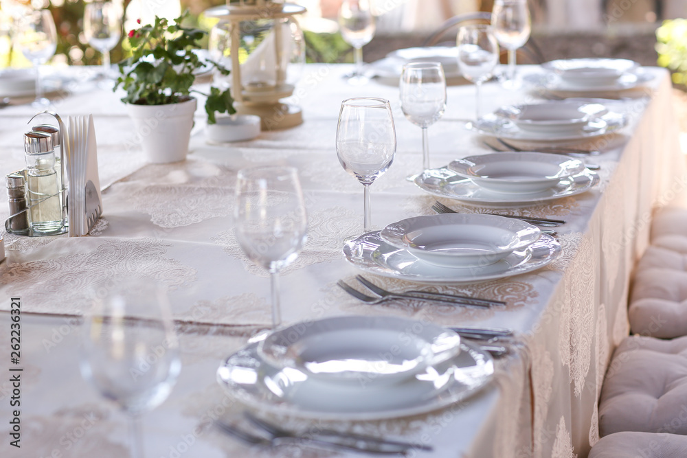Elegant table set with cutlery, plates and glasses.