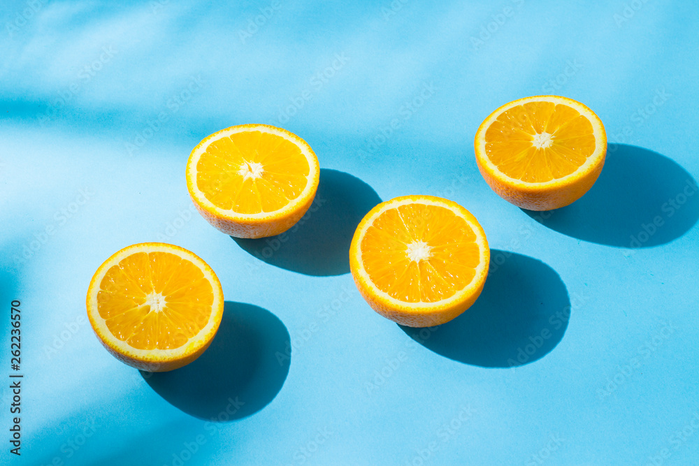 Oranges on a blue background under natural light with shadows. Hard light. Concept of diet, healthy eating, rest in the tropics, vacation and travel, vitamins. Oranges on a blue background under natural light with shadows. Hard light. Concept of diet, healthy eating, rest in the tropics, vacation and travel, vitamins.