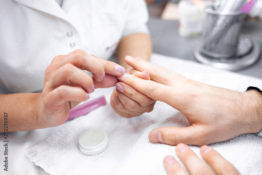 Nail grooming on the man hands during manicure treatment Nail grooming on the man hands during manicure treatment