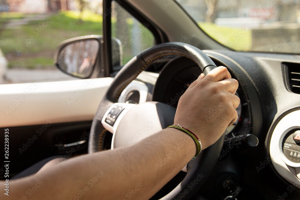 Cropped hands of man holding steering wheel