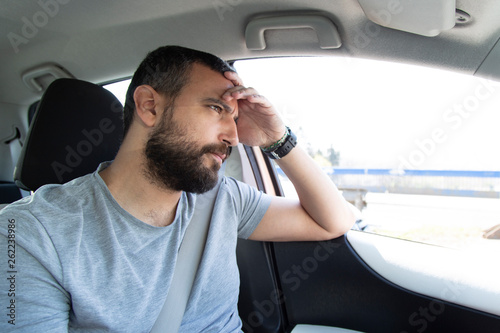 Portrait of handsome worried man driving car