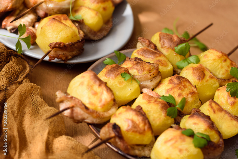 Close-up of rustic skewers with bacon in rustic style