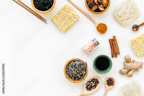 Chinese and Japanese food cooking with ginger, spices and noodles on white background top view mockup photo