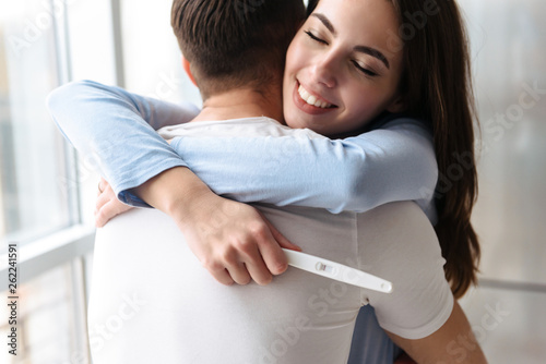 Lovely young couple holdingpregnancy test photo