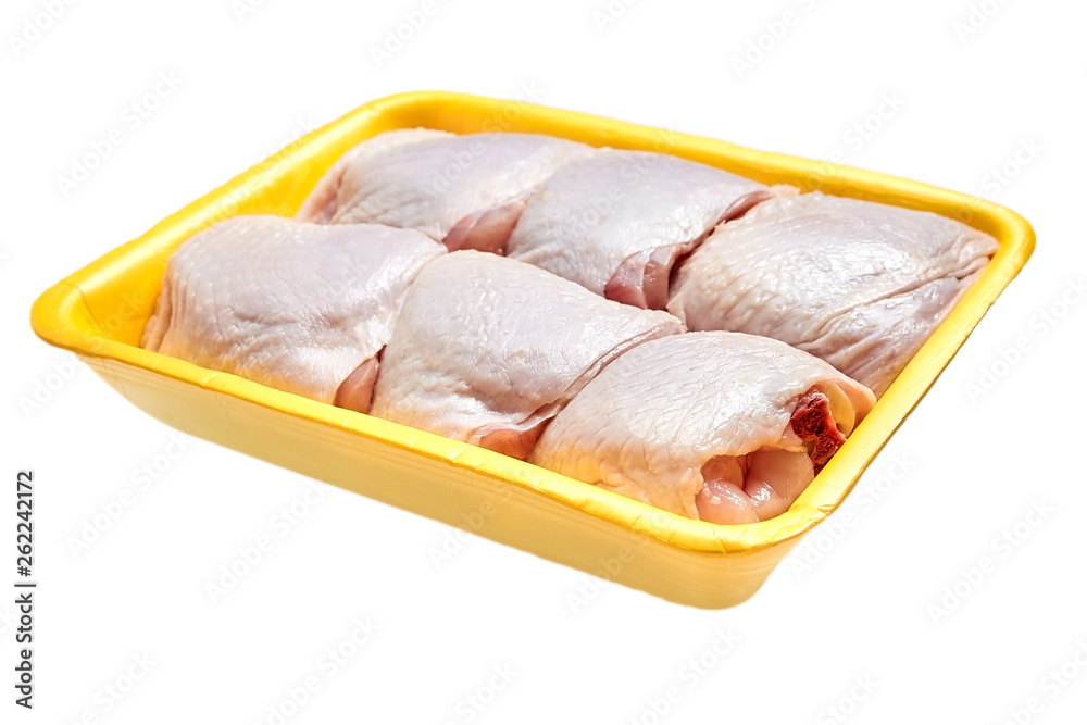 Raw chicken thighs in a yellow tray isolated on white background Raw chicken thighs in a yellow tray isolated on white background
