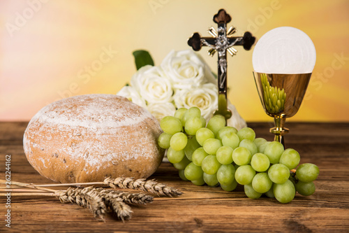 Holy communion a golden chalice with grapes and bread wafers 