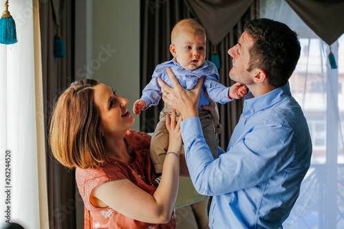 Wallpaper Mural Happy young parents posing with their baby boy in hotel room Torontodigital.ca