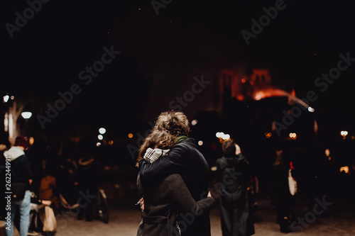 Un jeune couple triste devant la Cathédrale Notre Dame de Paris ravagée par les flammes