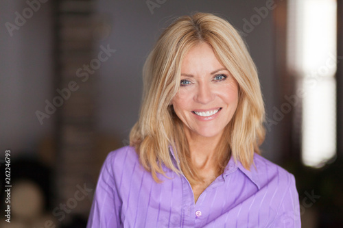 Mature woman smiling at the camera. She relaxing at home