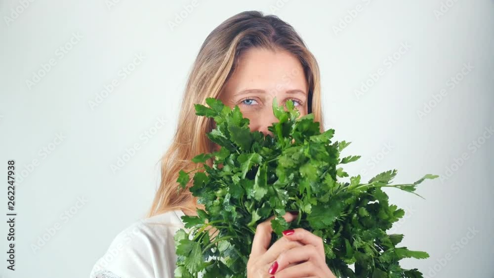 Portrait of a beautiful happy young woman with a bouquet of fresh parsley Portrait of a beautiful happy young woman with a bouquet of fresh parsley