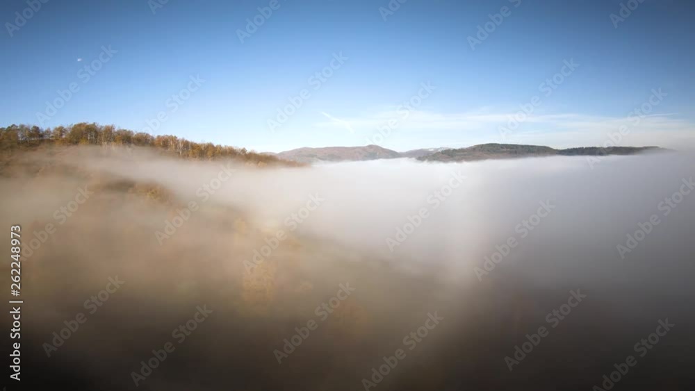 AERIAL: Flying above foggy forest treetops. Thick misty clouds rising from forest on cold morning day. AERIAL: Flying above foggy forest treetops. Thick misty clouds rising from forest on cold morning day.