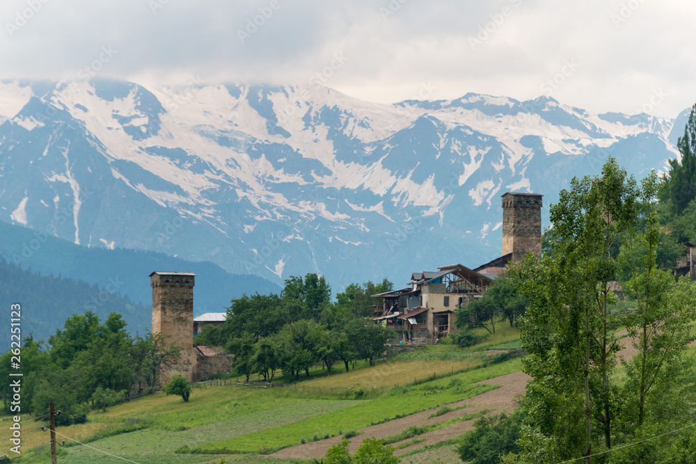 Mestia, Georgia - Jun 23 2018: Ancient towers with Caucasus Mountains in Mestia, Samegrelo-Zemo Svaneti, Georgia. Mestia, Georgia - Jun 23 2018: Ancient towers with Caucasus Mountains in Mestia, Samegrelo-Zemo Svaneti, Georgia.
