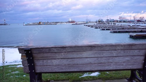 Behind a wooden bench at a boat dock in the winter. photo