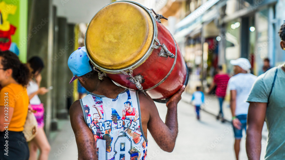 Fototapeta Hawana, Kuba. Mężczyzna idzie ulicą z bębnem na ramieniu.