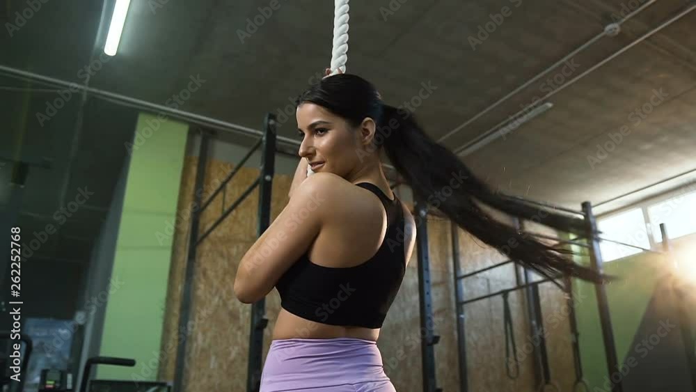 Attractive fit woman looking to the camera and smiling on the crossfit smoke background. Attractive fit woman looking to the camera and smiling on the crossfit smoke background.