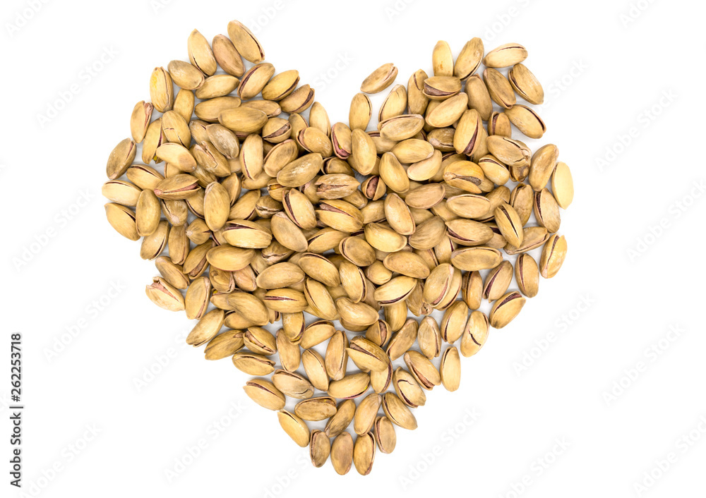 Pistachios in the form of hearts. A handful of pistachios on a white background