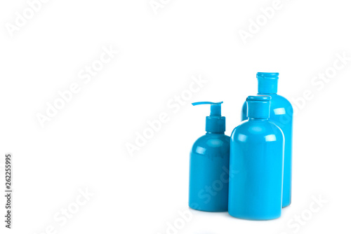 Blue cosmetic bottles with spray and caps isolated on white