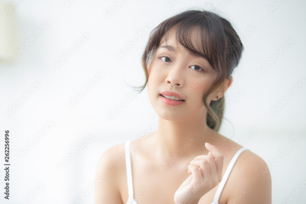 Portrait of beautiful young asian woman smile while wake up healthy and wellness with sunrise at morning in the bedroom, asia girl skin care with happy with fresh, lifestyle and relax concept.
